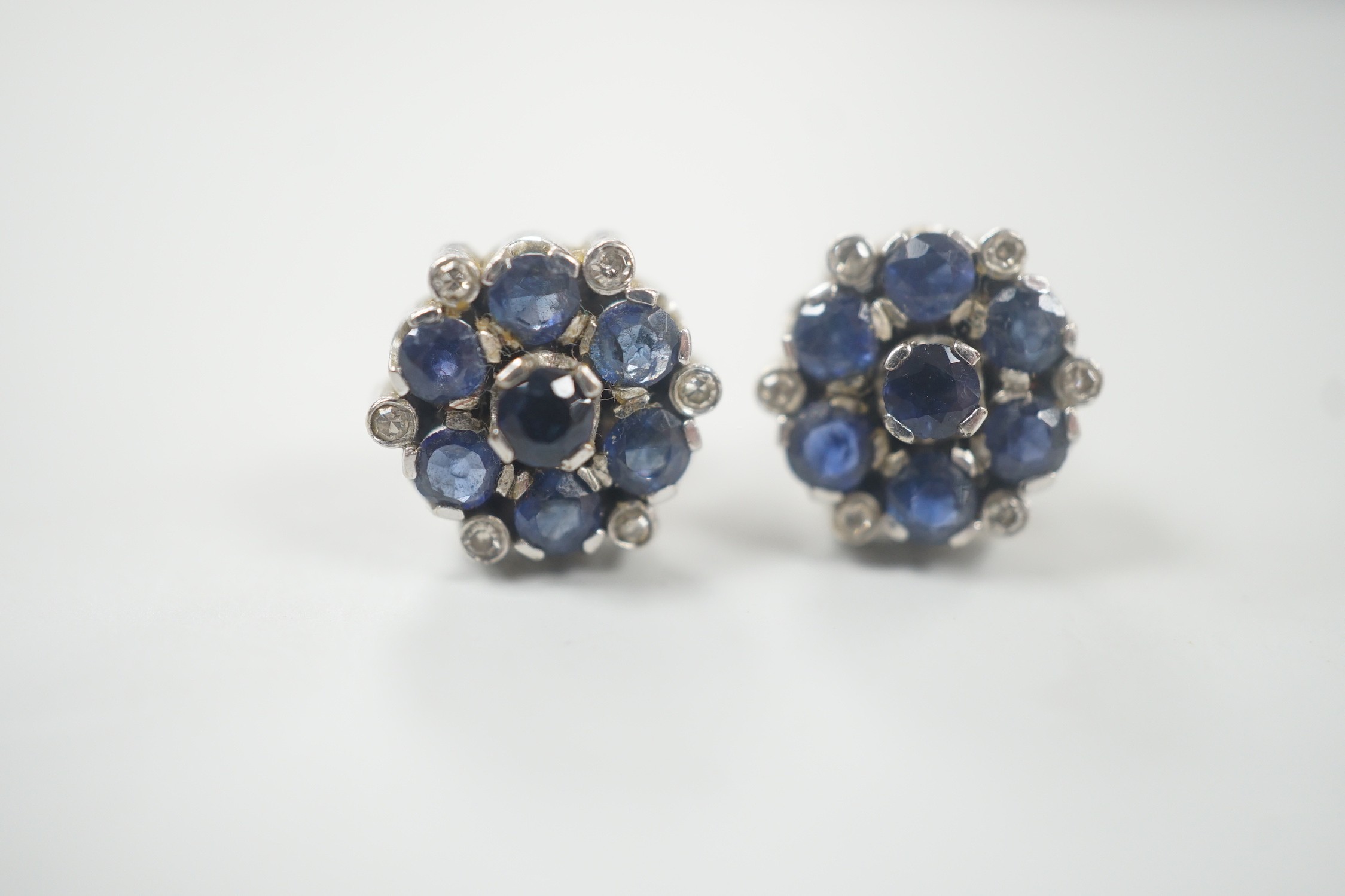 A pair of white metal, sapphire and diamond cluster set flower head ear studs, 10mm, gross weight 4.6 grams.